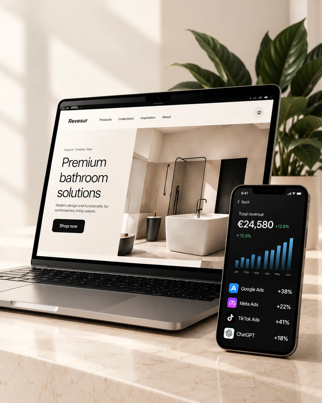 Laptop showing an online store and a phone showing a marketing dashboard on a marble desk, next to a plant